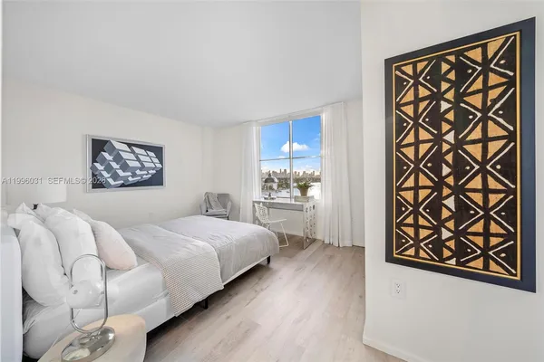 a bedroom with a bed and a refrigerator