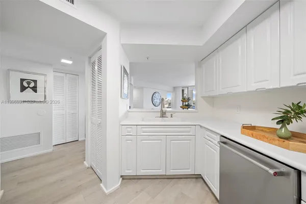a kitchen with white cabinets and sink