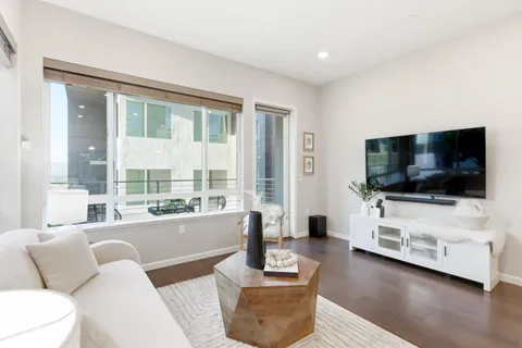 a dining room with stainless steel appliances kitchen island granite countertop furniture wooden floor and a kitchen view