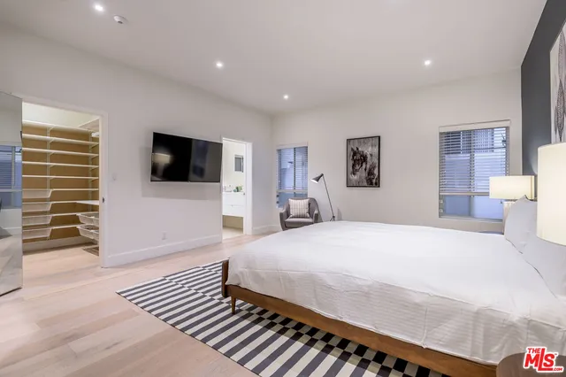 a bedroom with a bed and a flat screen tv