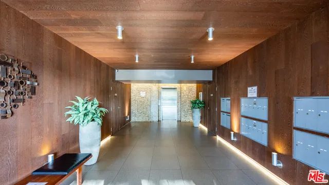 a hallway with a vase of flowers on wooden floor