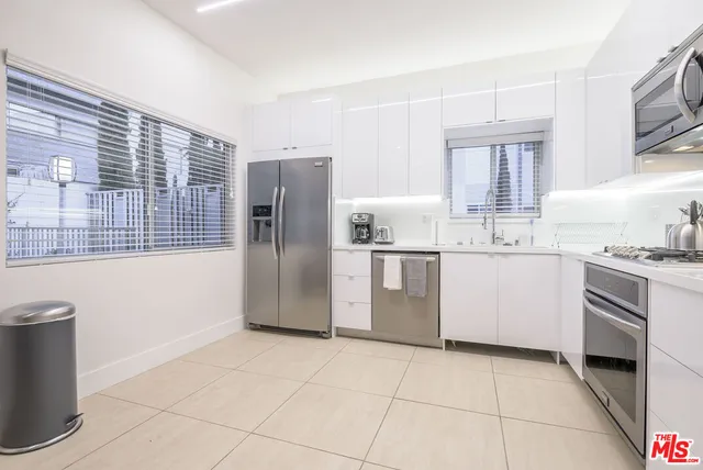 a kitchen with a refrigerator sink and cabinets