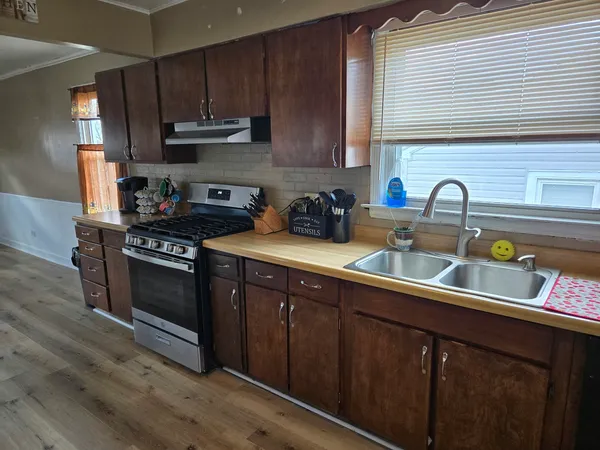 a kitchen with stainless steel appliances granite countertop a sink stove and cabinets