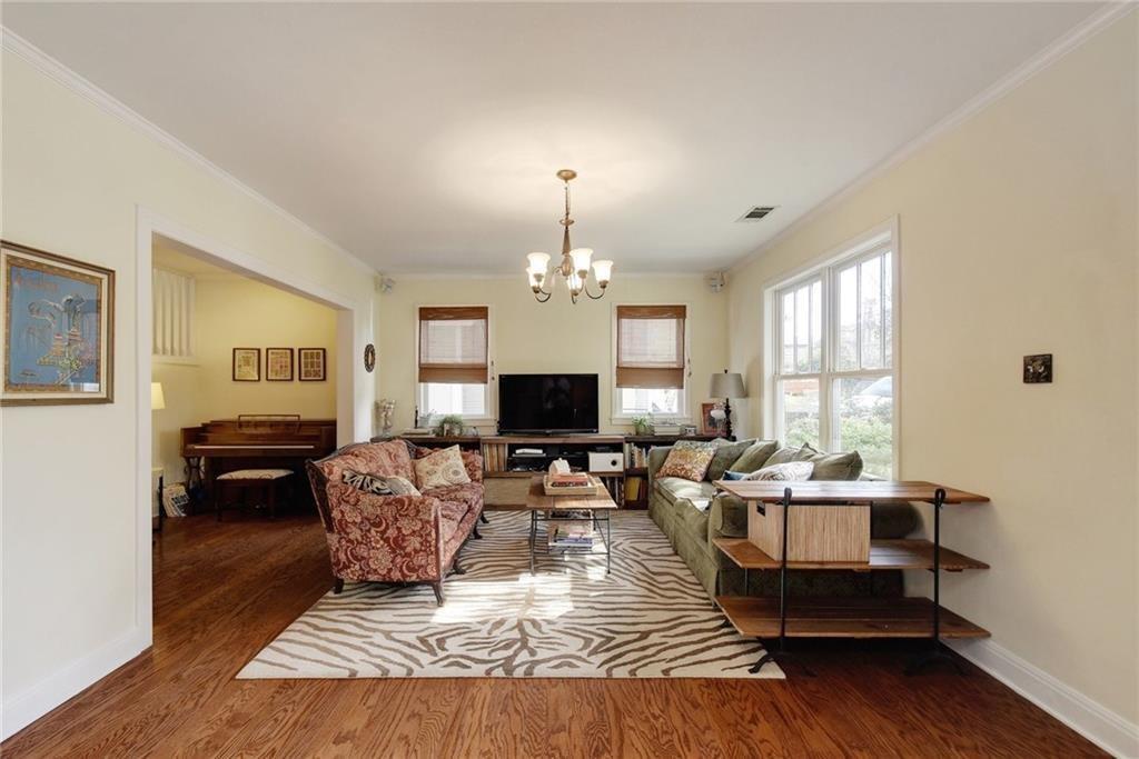 4412 Barrow Avenue, Unit A Austin, TX 78751 - Photo 5 of 28 Living room featuring crown molding, wood finished floors, and a chandelier