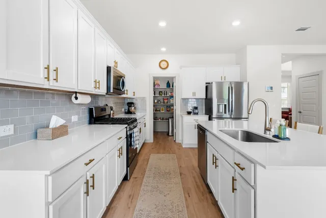 a kitchen with stainless steel appliances granite countertop a sink and cabinets