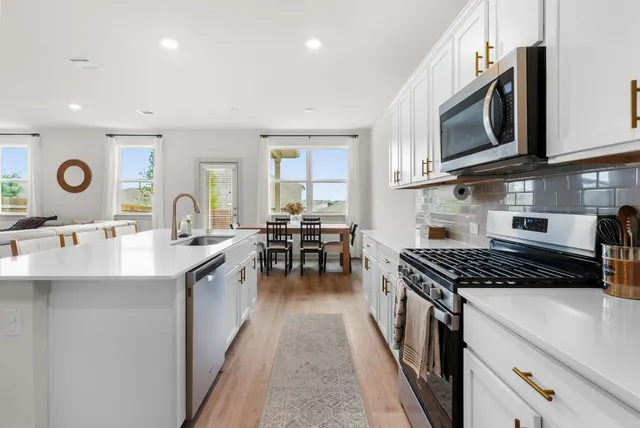 a kitchen with stainless steel appliances granite countertop a stove and a sink