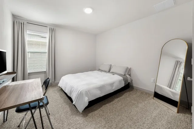 a bedroom with a bed and a window