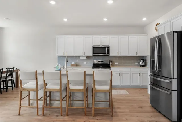 a kitchen with a sink stainless steel appliances and white cabinets