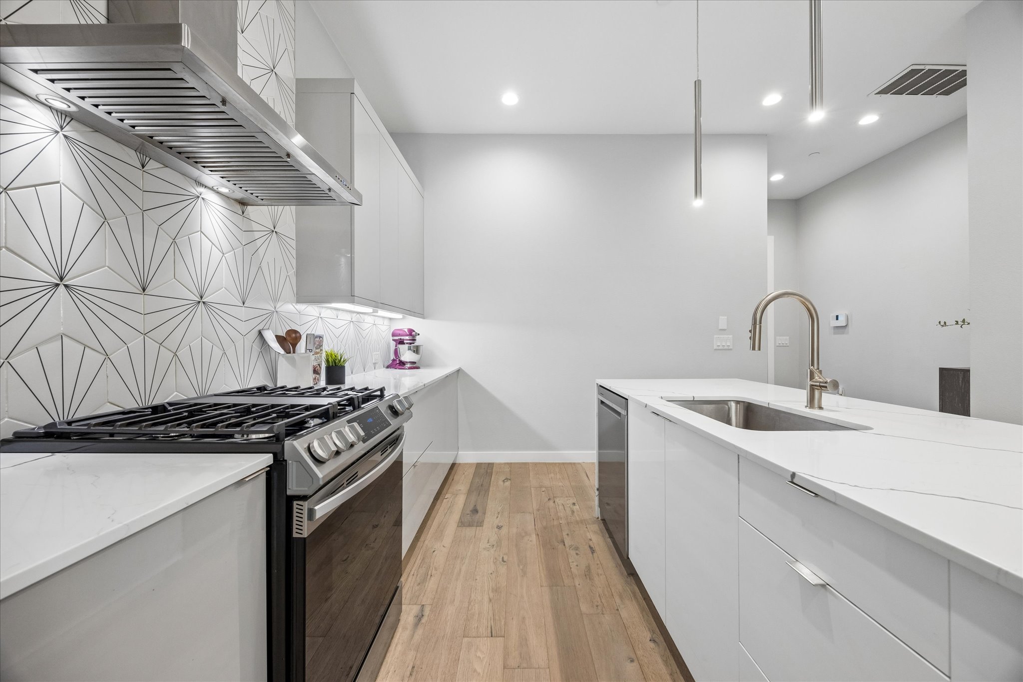 2108 Tillery Street, Unit 9 Austin, TX 78723 - Photo 6 of 25 Designer tile backsplash, gas range, and stainless steel appliances