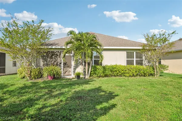 a view of a house with a big yard and large trees