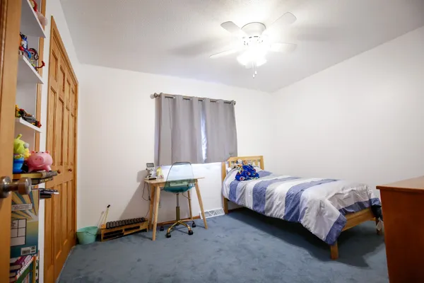 a spacious bedroom with a bed and a chandelier