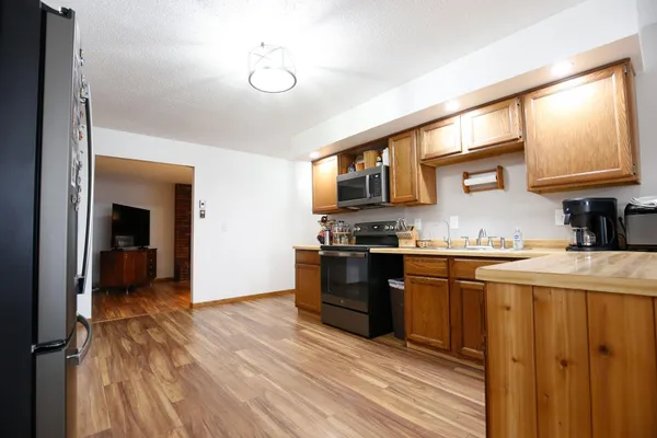 a kitchen with stainless steel appliances kitchen island wooden cabinets and refrigerator