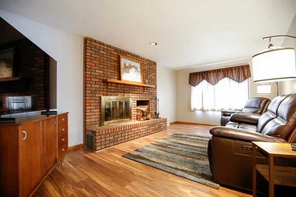a bedroom with furniture a flat screen tv and a fireplace