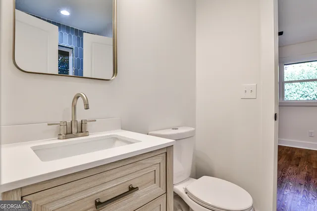 a bathroom with a sink a toilet and mirror
