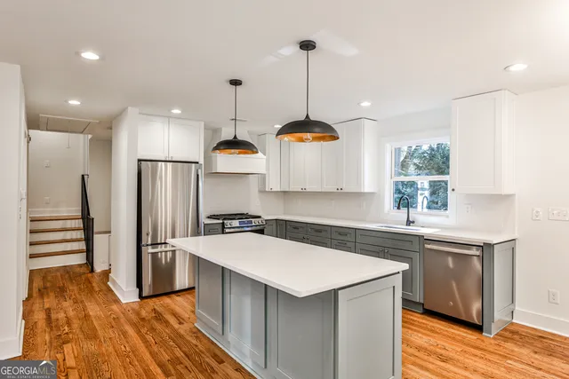 a kitchen with a sink a counter top space stainless steel appliances and cabinets