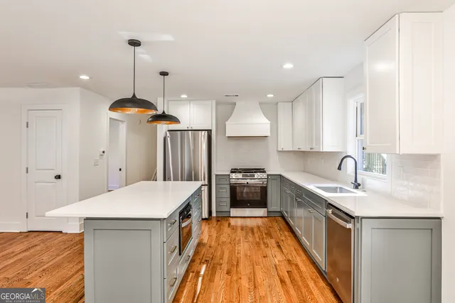 a large kitchen with kitchen island a stove a sink a refrigerator and a center island