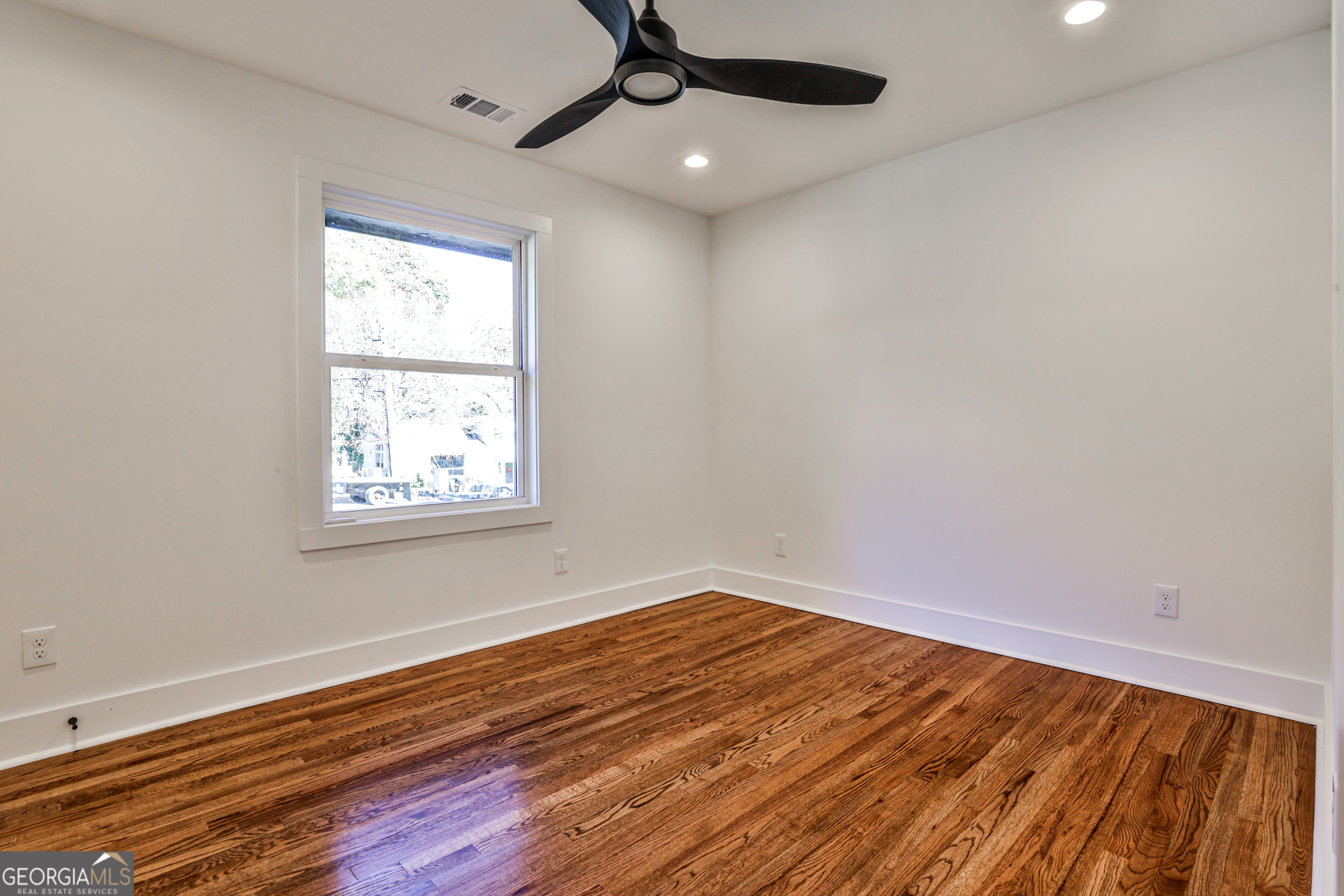 3029 Charlbury Place Avondale Estates, GA 30002 - Photo 22 of 27 an empty room with wooden floor ceiling fan and windows