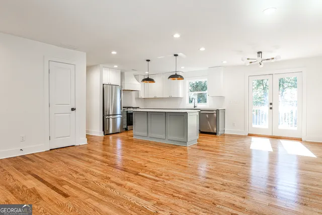 a view of kitchen with stainless steel appliances granite countertop a refrigerator and a stove top oven