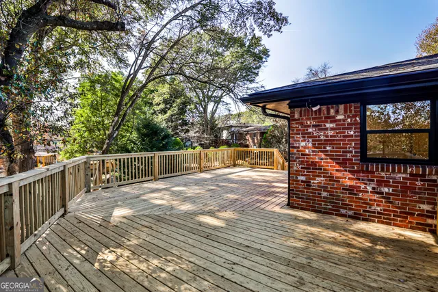 a view of a balcony with wooden floor and fence and a bench