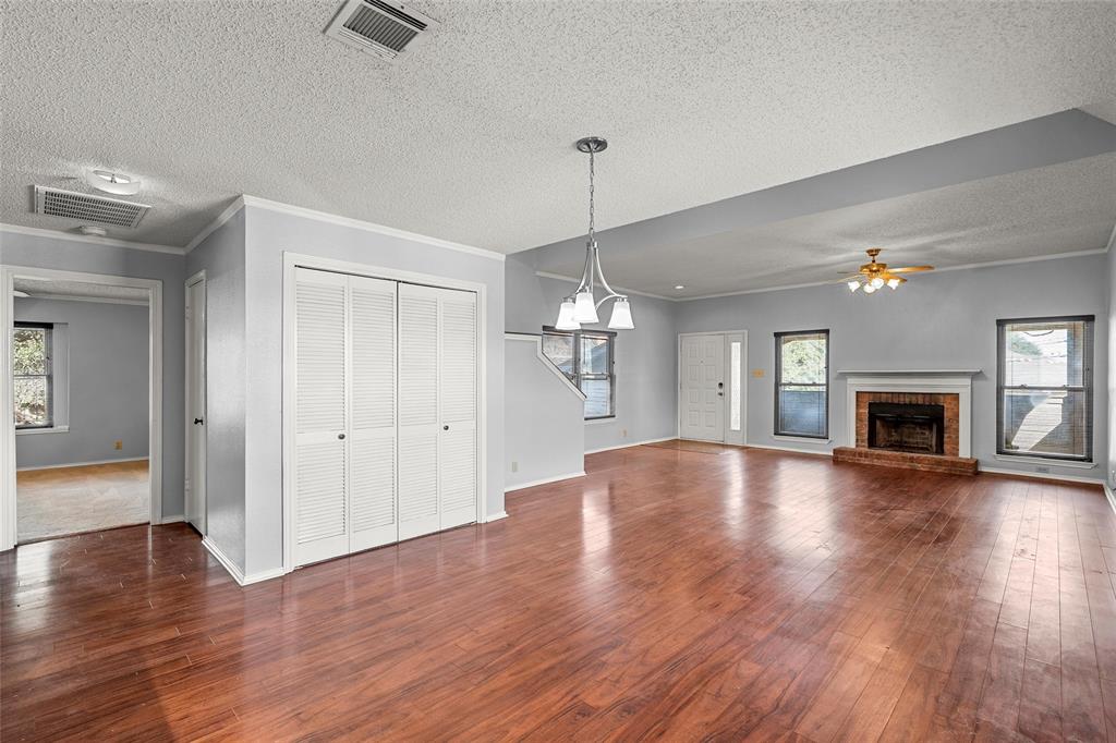 156 Pleasant Grove Lane, Unit 5 Waco, TX 76712 - Photo 11 of 37 a view of an empty room with wooden floor and a fireplace