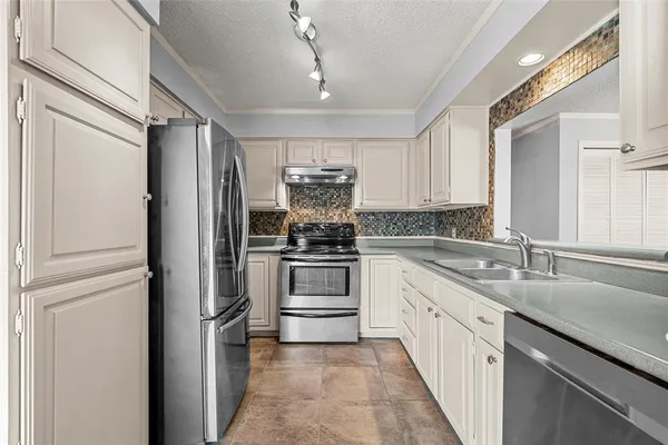 a kitchen with granite countertop white cabinets and appliances