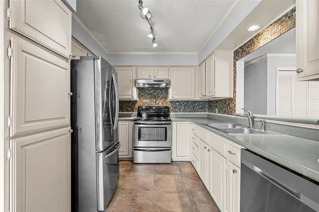 a kitchen with granite countertop white cabinets and appliances