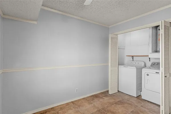 a view of a kitchen with refrigerator and white cabinets