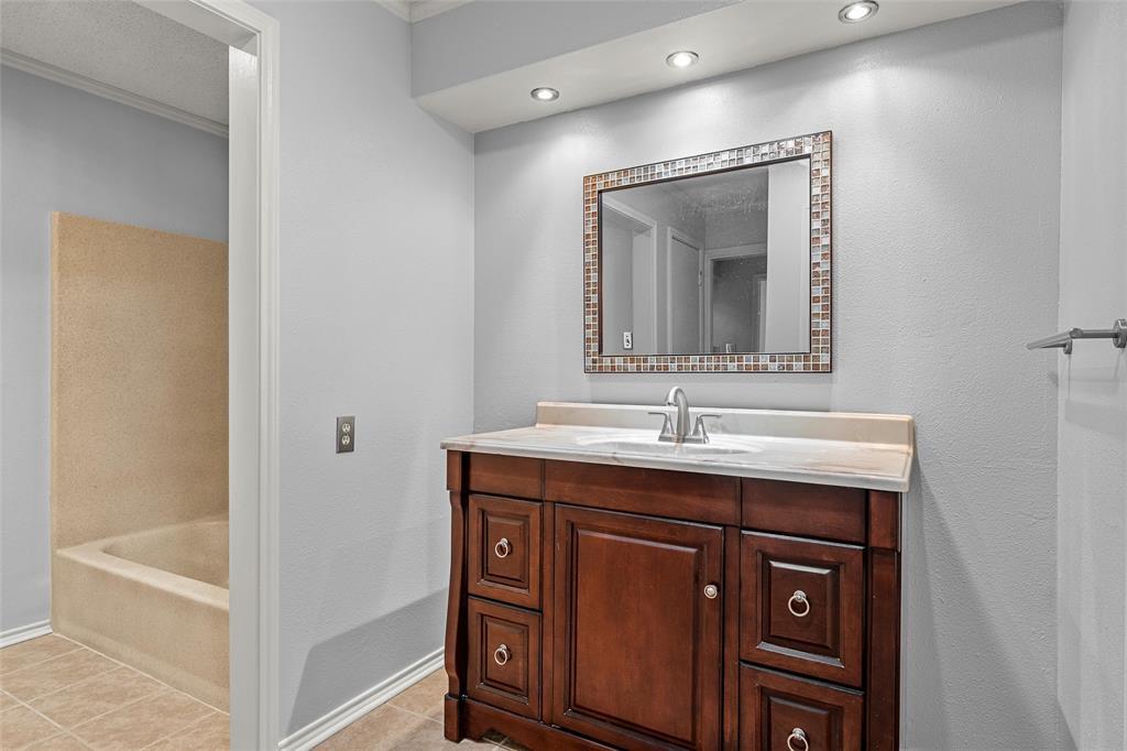 156 Pleasant Grove Lane, Unit 5 Waco, TX 76712 - Photo 23 of 37 a bathroom with a granite countertop sink a mirror and a bathtub