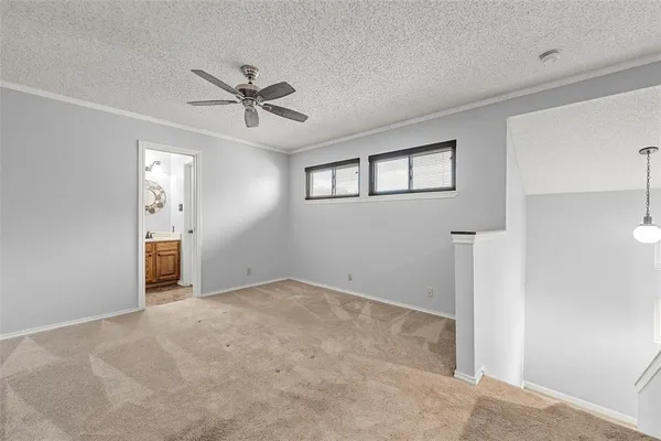a view of a livingroom with a chandelier fan and windows