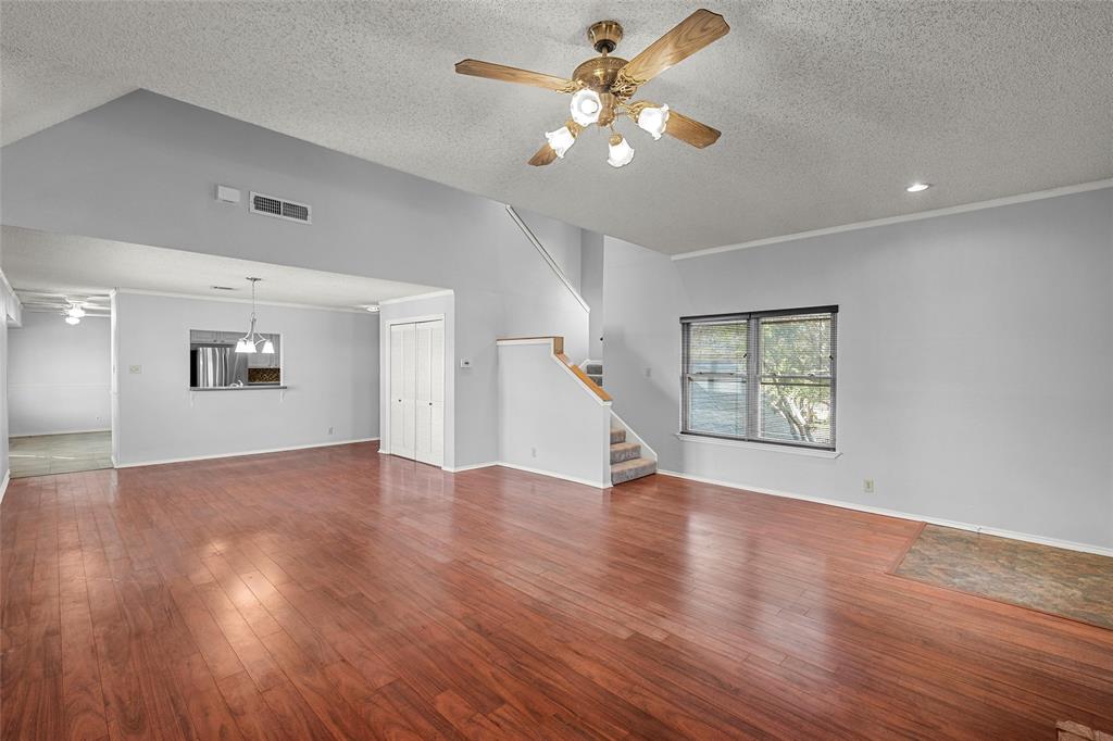156 Pleasant Grove Lane, Unit 5 Waco, TX 76712 - Photo 9 of 37 a view of an empty room with wooden floor and a ceiling fan