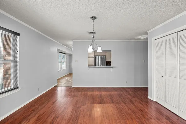 a view of an empty room with wooden floor and a fireplace