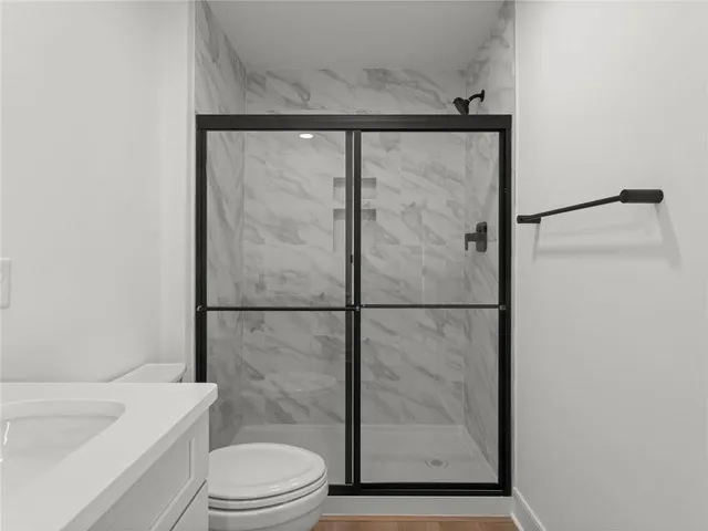 a bathroom with a shower a toilet and a sink