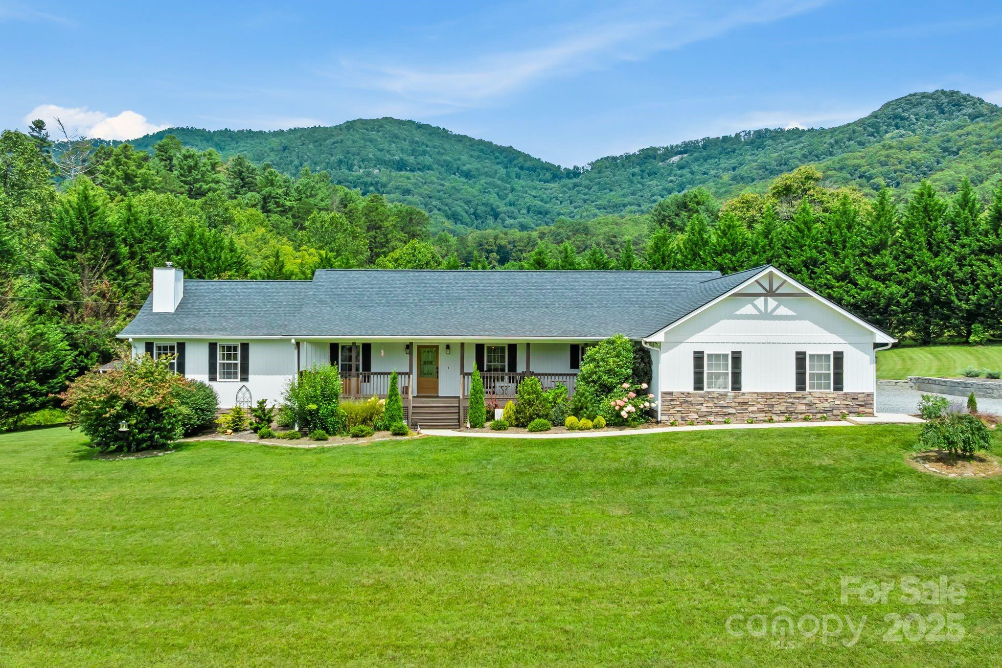 a front view of a house with a yard and green space