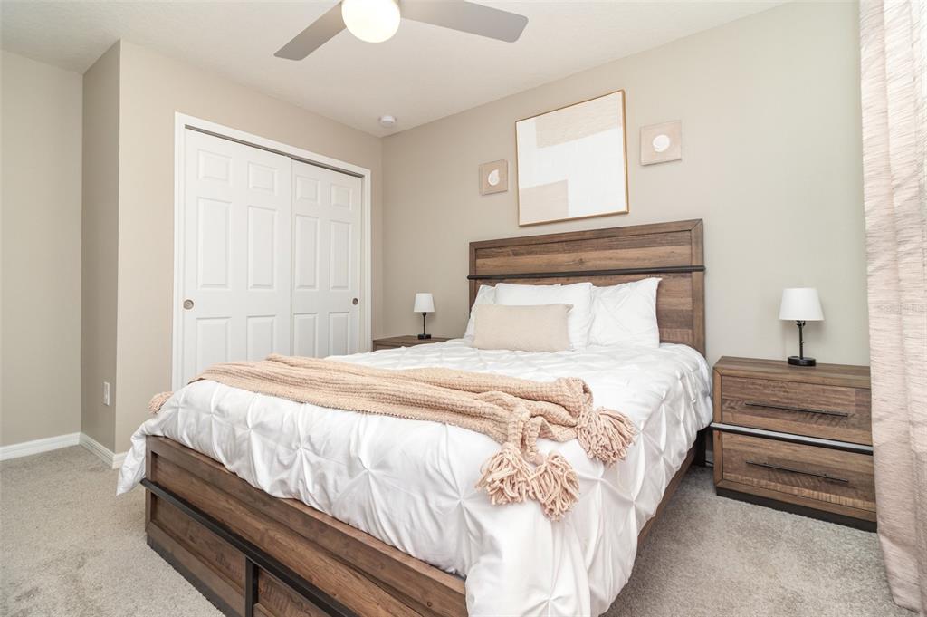 2461 Avian Loop Kissimmee, FL 34741 - Photo 20 of 36 a bedroom with a bed and a chandelier