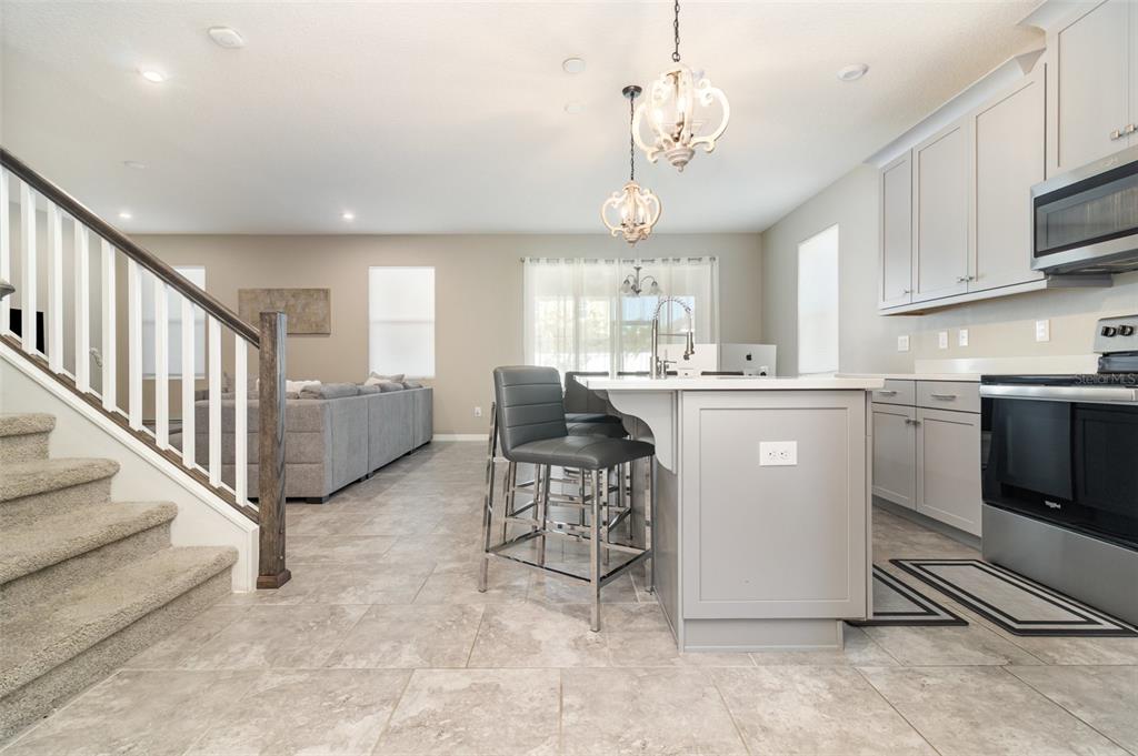 2461 Avian Loop Kissimmee, FL 34741 - Photo 6 of 36 a open kitchen with cabinets a sink and appliances