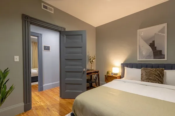 a bedroom with a bed and a painting on the wall