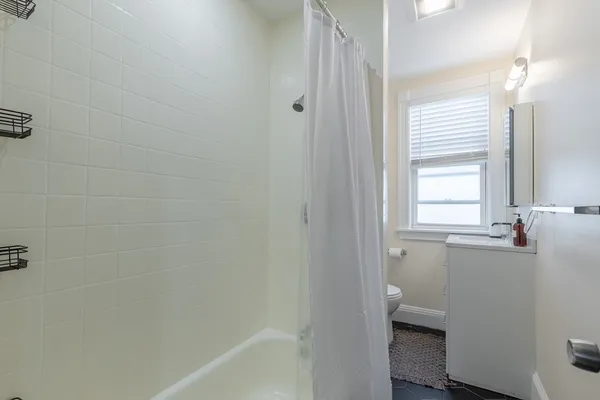 a bathroom with a granite countertop sink a toilet and shower