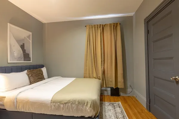 a bedroom with a bed and a painting on the wall