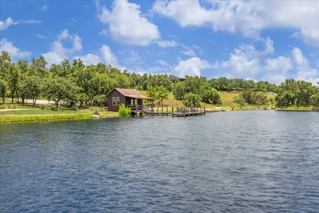 a front view of a house with a yard and lake view