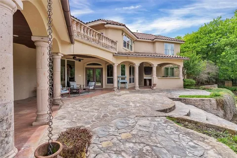 a view of a white house with a outdoor space and garden