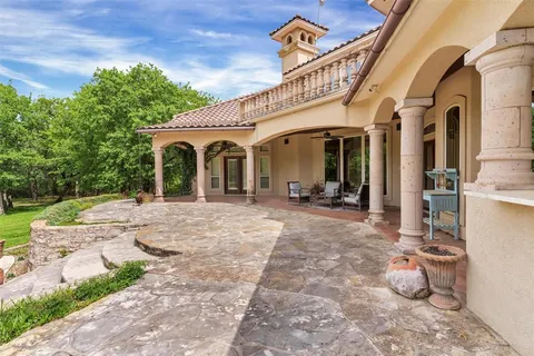 a living room with stainless steel appliances kitchen island granite countertop a sink and a black countertop next to a window