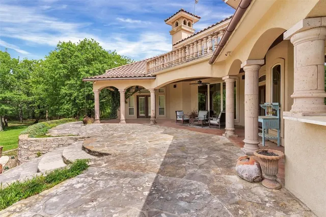 a living room with stainless steel appliances kitchen island granite countertop a sink and a black countertop next to a window