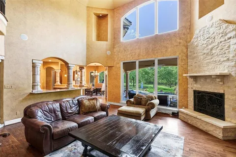 a kitchen with stainless steel appliances kitchen island granite countertop a table chairs in it and wooden floors