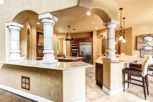 a kitchen with stainless steel appliances granite countertop a sink a stove and a refrigerator