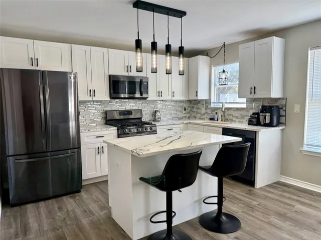 a kitchen with a sink cabinets and refrigerator