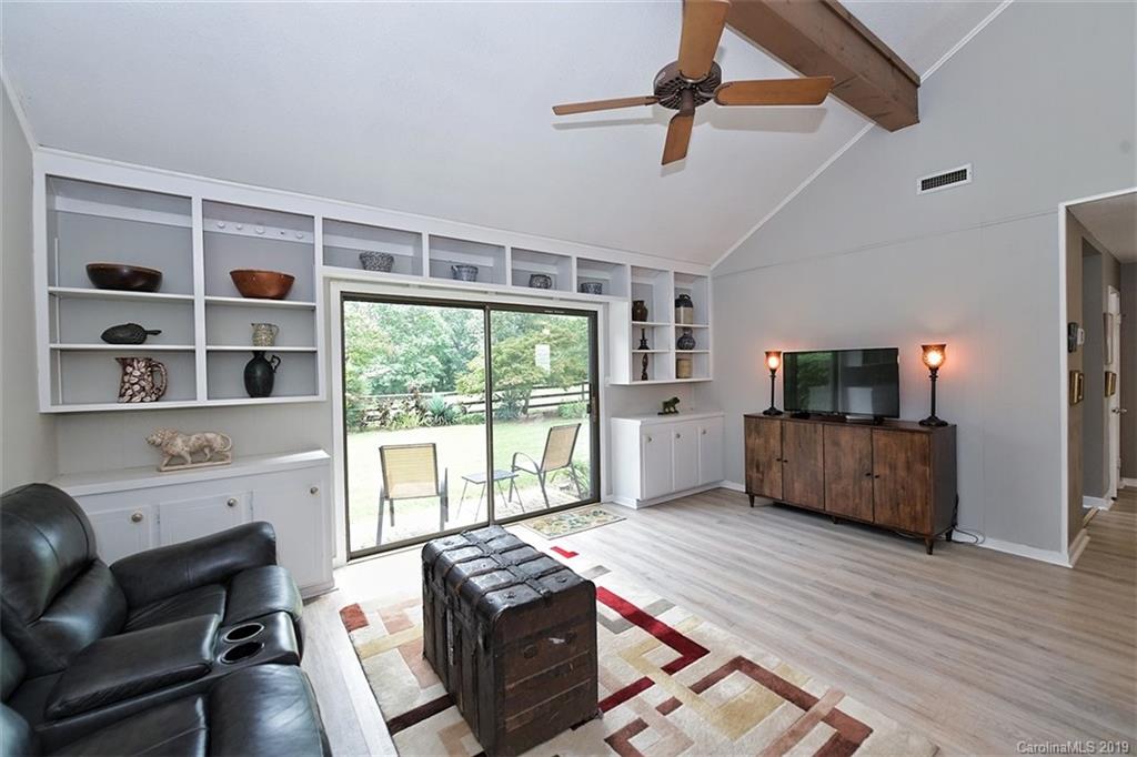 4231 Rounding Run Road Charlotte, NC 28277 - Photo 22 of 47 a living room with furniture a flat screen tv and a floor to ceiling window