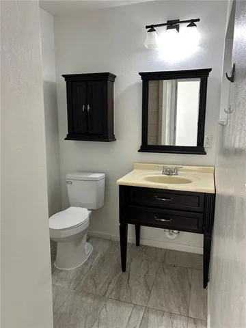 a bathroom with a toilet a sink and a mirror