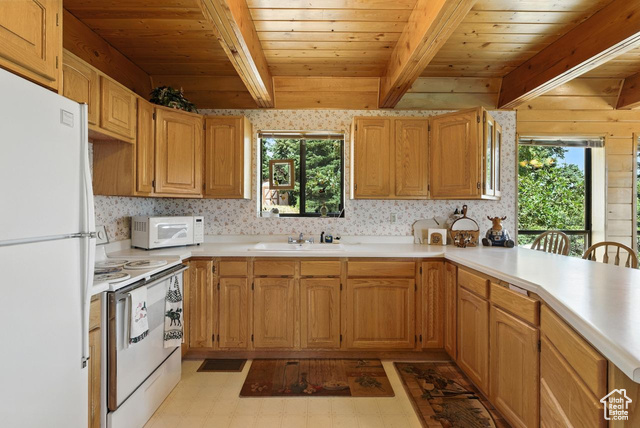 1180 Oak Road Coalville, UT 84017 - Photo 4 of 25 Kitchen featuring light flooring, white appliances, a wood ceiling with exposed beams, light countertops, and a peninsula