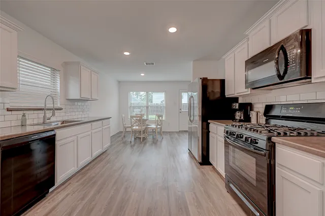a kitchen with a stove a sink and a microwave