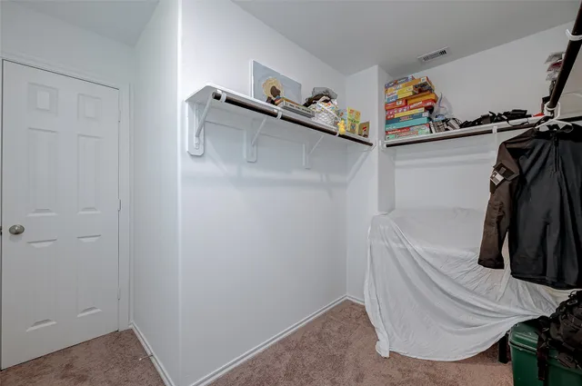 a view of walk in closet with clothes and shoes